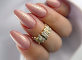 Manicure hybrydowy w kształcie migdałków w różowym odcieniu z efektem cat eye, wykonany lakierem Plotki pod palmami.